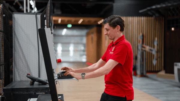 Medewerker van De Groot Bewerkingsmachines aan het werk in de software in een CNC machine